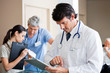 Photo: Male Doctor Using Digital Tablet Male Doctor Using Digital Tablet