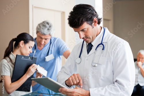 Photo: Male Doctor Using Digital Tablet Male Doctor Using Digital Tablet