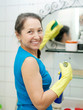 mature woman  cleans  mirror in bathroom