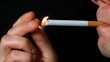 Man lighting up cigarette with match