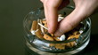 Hand putting cigarette out in ashtray