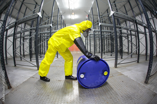 Photo: fully protected technician,rolling a barrel wh toxic substance fully protected technician,rolling a barrel wh toxic substance