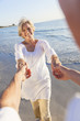Happy Senior Couple Dancing Holding Hands on A Tropical Beach