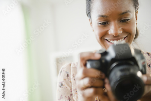 Photo: Black woman using digital SLR camera Black woman using digital SLR camera