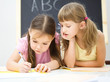 Little girls are writing using a pen
