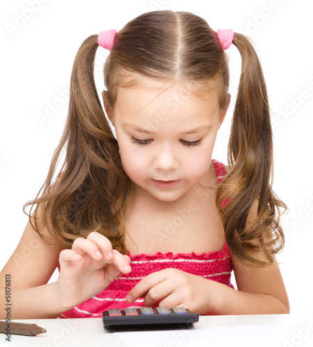 Photo: Little girl is using calculator Little girl is using calculator