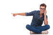 seated man on phone points to side