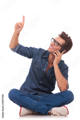 Photo: man on phone sits, points & looks up man on phone sits, points & looks up