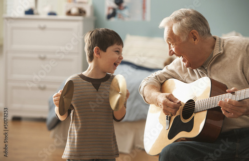 Photo: Caucasian man and grandson playing musical instruments together Caucasian man and grandson playing musical instruments together