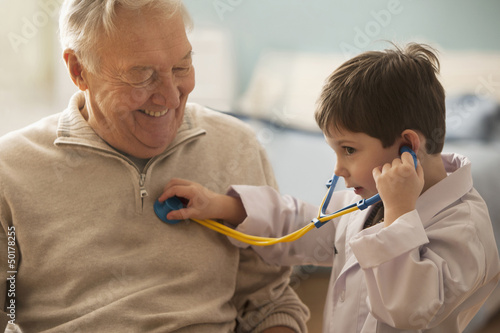 Photo: Caucasian boy listening to grandfather's heartbeat with stethoscope Caucasian boy listening to grandfather's heartbeat with stethoscope