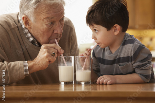 Photo: Caucasian grandfather and grandson drinking milk together Caucasian grandfather and grandson drinking milk together