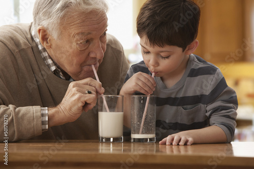 Photo: Caucasian grandfather and grandson drinking milk together Caucasian grandfather and grandson drinking milk together