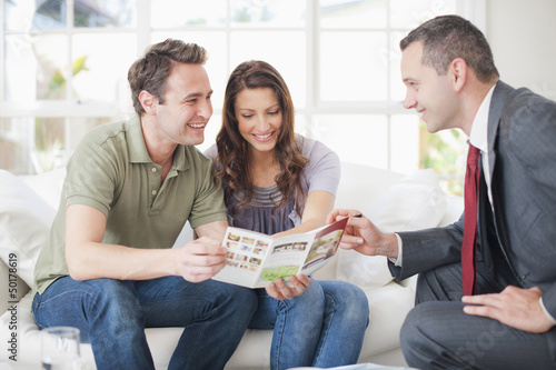 Photo: Hispanic couple talking with financial advisor Hispanic couple talking with financial advisor