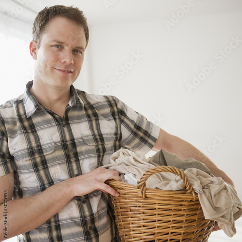 Photo: Caucasian man holding laundry basket Caucasian man holding laundry basket