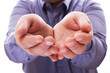 A man holds a handful, hands together, asks