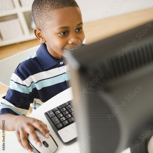 Photo: Black boy using computer Black boy using computer