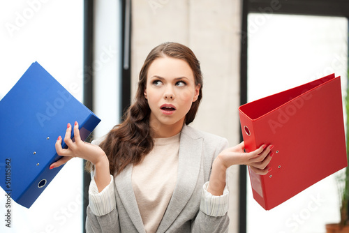 Photo: unsure thinking or wondering woman with folder unsure thinking or wondering woman with folder