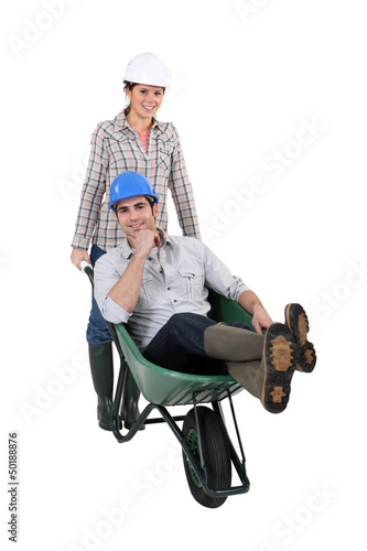 Photo: Woman pushing a man in a wheelbarrow Woman pushing a man in a wheelbarrow