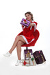 Cheeky Miss Santa sitting surrounded by Christmas presents