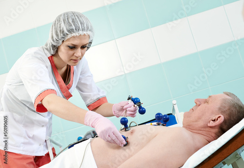 Photo: medic nurse with patient at electrocardiogram medic nurse with patient at electrocardiogram