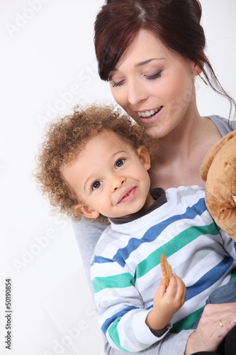 Photo: Mother and her son eating a cookie. Mother and her son eating a cookie.