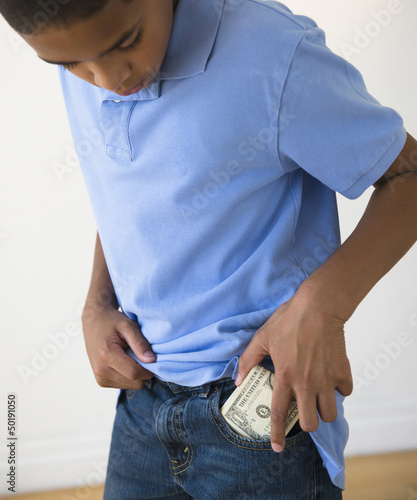 Photo: Hispanic boy putting in pocket Hispanic boy putting in pocket