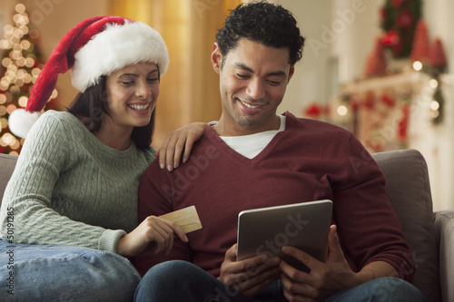 Photo: Couple using digital tablet to buy Christmas gifts Couple using digital tablet to buy Christmas gifts