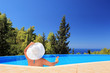 A woman relaxing in a swimming pool with cocktail