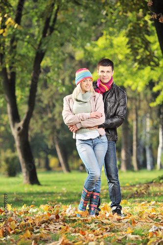 Photo: A loving couple hugging in park in autumn A loving couple hugging in park in autumn