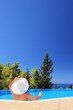 Woman relaxing in a swimming pool with cocktail
