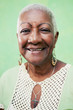 Foto: Portrait of senior black woman smiling at camera on green backgr Portrait of senior black woman smiling at camera on green backgr