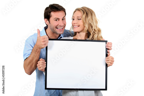 Photo: Couple holding white board Couple holding white board