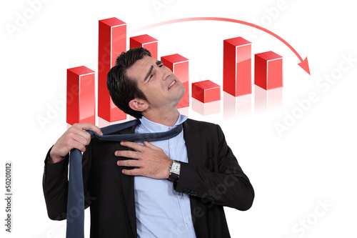Photo: Stressed businessman with a downturn graph Stressed businessman with a downturn graph