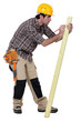 Man marking a measurement on a wooden plank