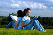 Two girls students studying reading outdoors