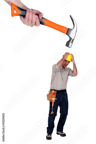 Photo: Scared builder shielding himself from giant hammer Scared builder shielding himself from giant hammer
