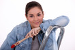 portrait of cute female painter on ladder holding paintbrush