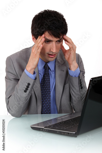 Photo: A businessman having a headache. A businessman having a headache.