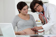 Doctor checking pregnant woman's belly