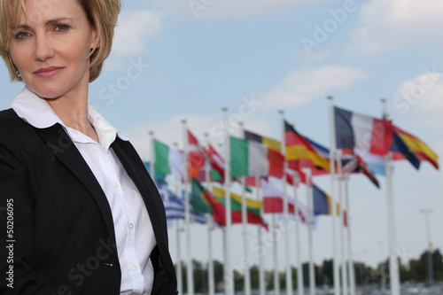 Photo: A woman looking at us with European flags in the background. A woman looking at us with European flags in the background.