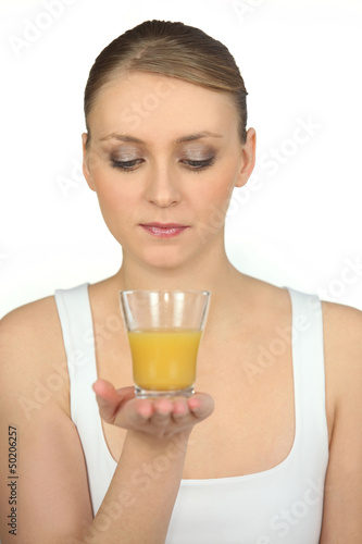 Photo: Woman with glass of orange juice in hand Woman with glass of orange juice in hand