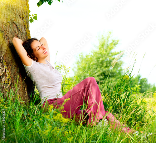 Photo: Beautiful Young Woman Relaxing outdoors. Nature Beautiful Young Woman Relaxing outdoors. Nature