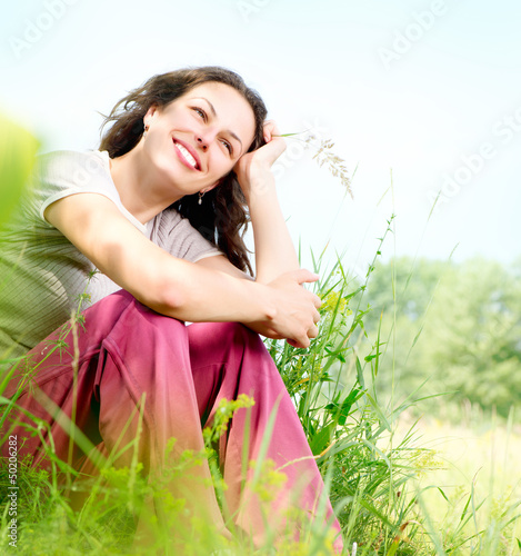 Photo: Beautiful Young Woman Outdoors. Enjoy Nature. Meadow Beautiful Young Woman Outdoors. Enjoy Nature. Meadow