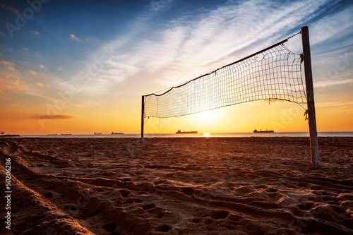 Photo: Volleyball net and sunrise on the beach Volleyball net and sunrise on the beach