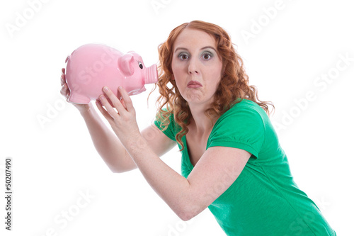 Photo: Witzig: junge Frau mit Sparschwein isoliert schneidet Grimasse Witzig: junge Frau mit Sparschwein isoliert schneidet Grimasse