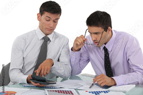 Photo: Businessmen scrutinizing financial results Businessmen scrutinizing financial results