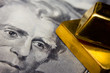 Close-up of a 20-dollar banknote and gold bullions