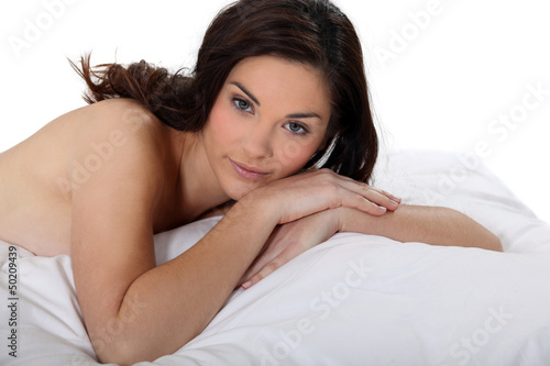 Photo: Portrait of a nude woman lying on a bed Portrait of a nude woman lying on a bed