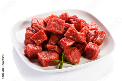 Photo: Raw beef and vegetables on white background Raw beef and vegetables on white background