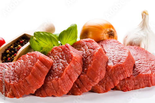 Photo: Raw beef and vegetables on white background Raw beef and vegetables on white background